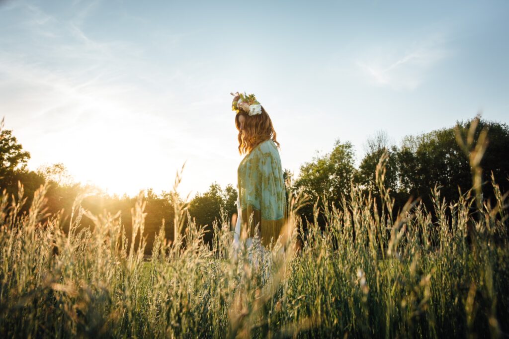 Golden hour. A woman glides through a meadow with a flower crown